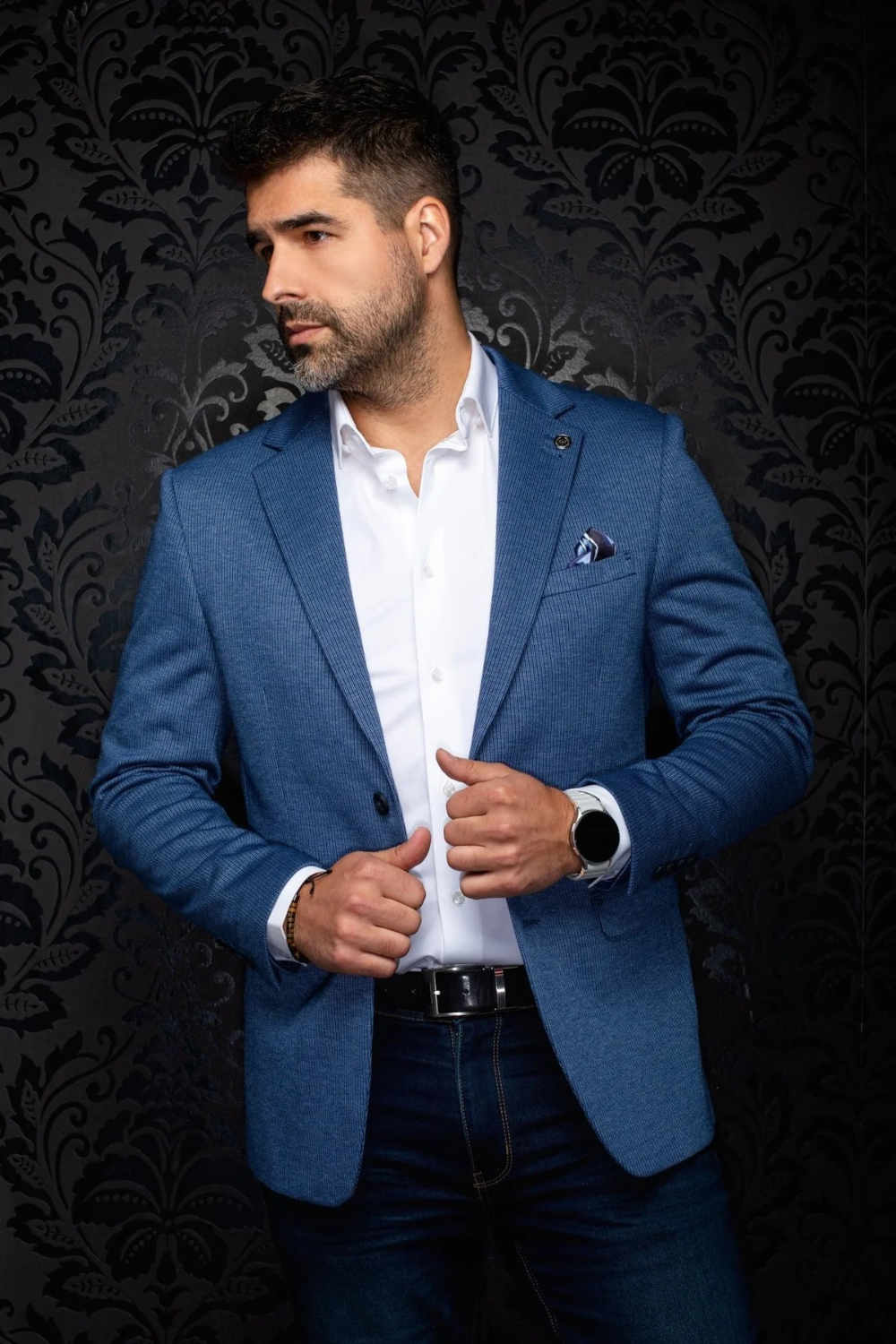 Broderick's Clothing Co. Au Noir EAMES medium blue blazer worn by a man with a white shirt against a damask background