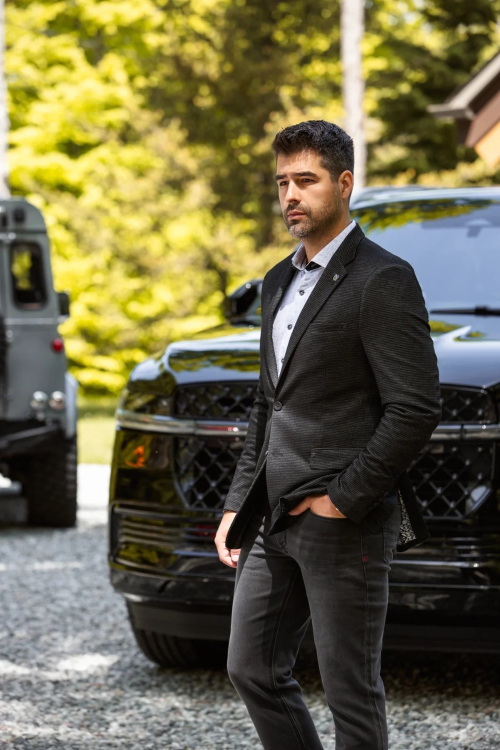Broderick's Clothing Co. Au Noir SCARPA blazer in black worn by a man standing outdoors near a black SUV