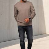 Man wearing a Broderick's Clothing Co. Au Noir LACAUNE beige cashmere crew neck sweater with dark jeans and sneakers.
