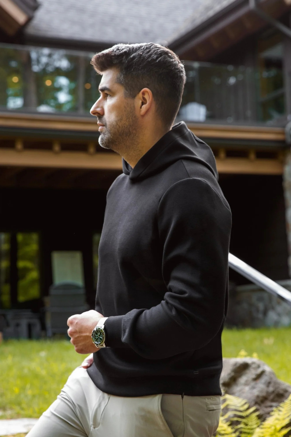 Broderick's Clothing Co. man wearing a minimalist black Au Noir KAIZEN pullover hoodie in a garden setting