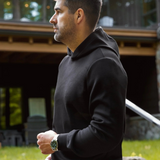 Broderick's Clothing Co. man wearing a minimalist black Au Noir KAIZEN pullover hoodie in a garden setting