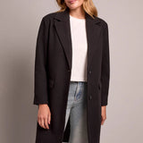 Broderick's Clothing Co. black knit car coat with notch lapels and button front worn by a woman.