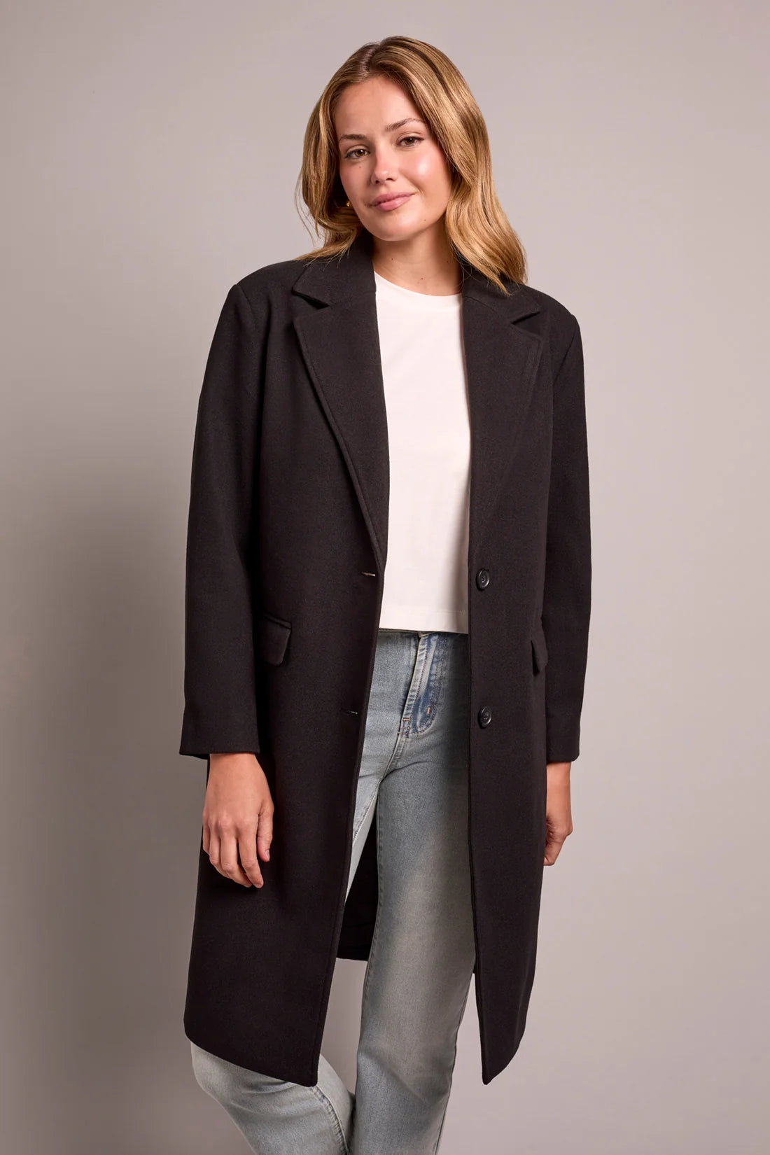 Broderick's Clothing Co. black knit car coat with notch lapels and button front worn by a woman.
