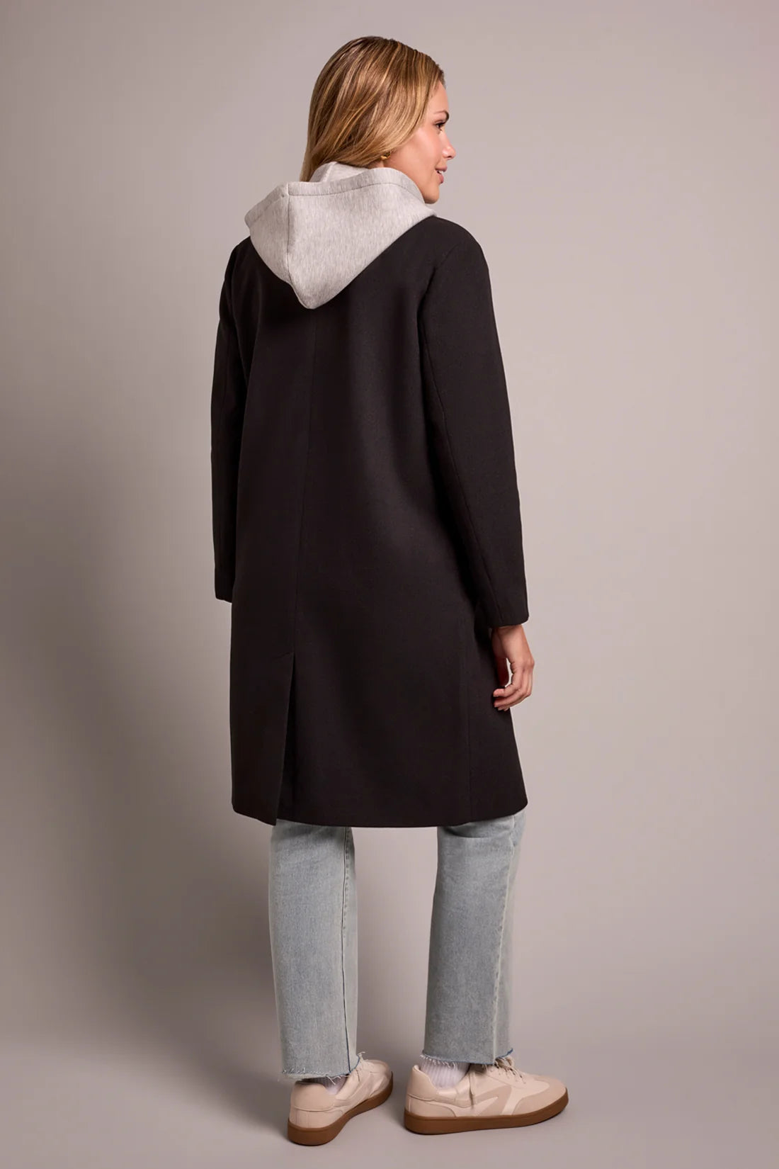 Broderick's Clothing Co. black knit car coat with grey removable fooler hoodie worn by a woman from the back view