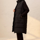 Model wearing a Broderick's Clothing Co. black longline quilted vest with a zip-front closure and side pockets.