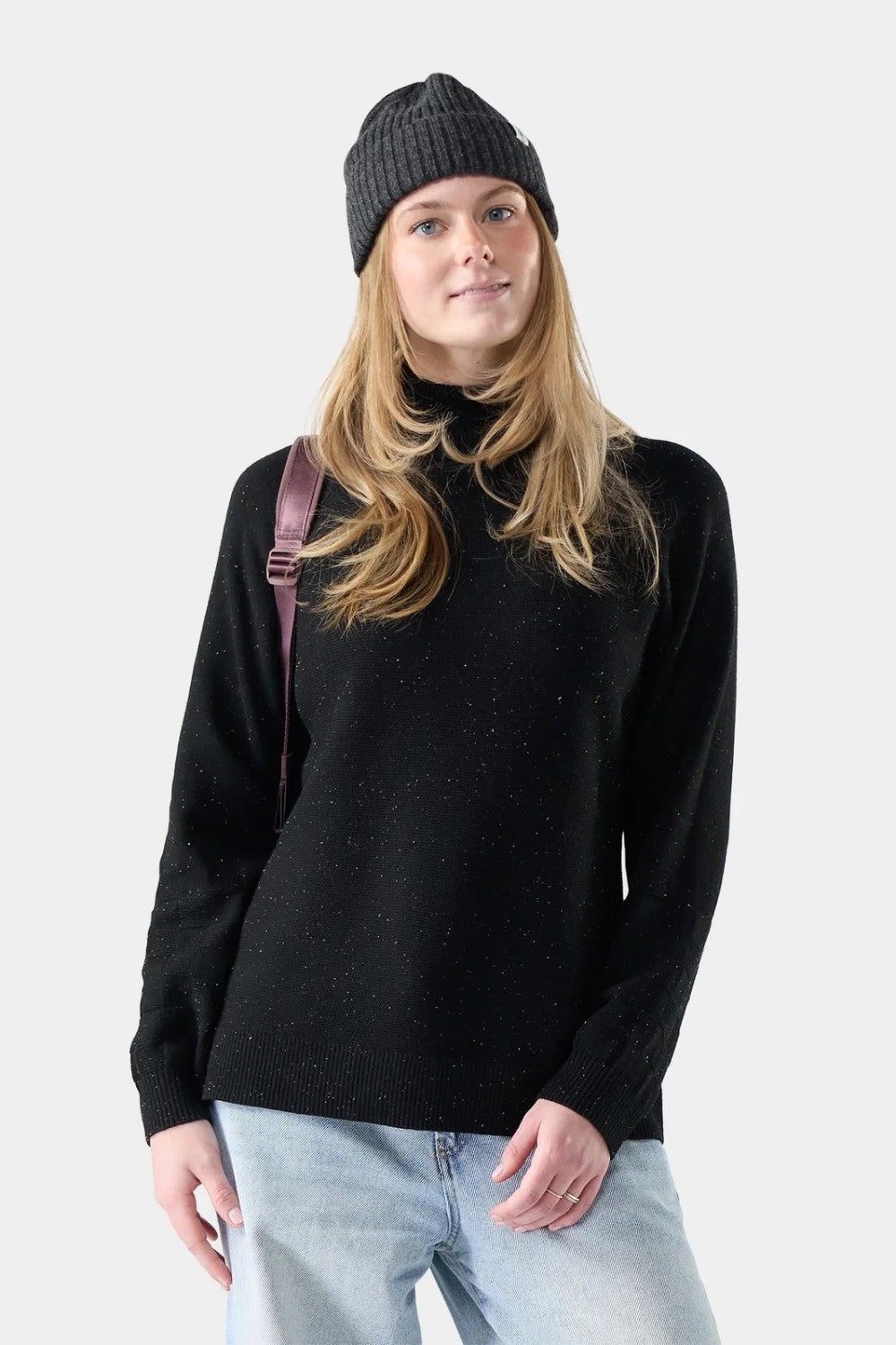 Broderick's Clothing Co. woman wearing a black speckled Merino wool blend tunic sweater and a grey knit beanie.