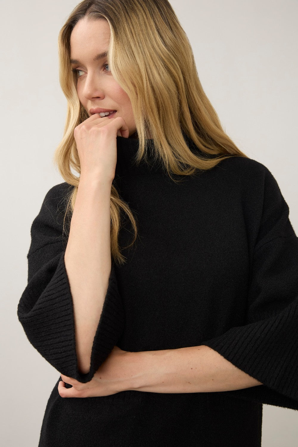 Broderick's Clothing Co. black mock neck sweater with three-quarter sleeves worn by a blonde woman