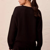 Broderick's Clothing Co. black Techno Lux scuba knit pullover with drop shoulders and ribbed hem, back view.