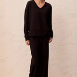 Broderick's Clothing Co. black V-neck pullover with drop shoulders in technical scuba knit worn with matching pants.