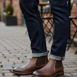 Broderick's Clothing Co. Florsheim Lodge brown leather Chelsea boots worn with dark denim jeans on a cobblestone street