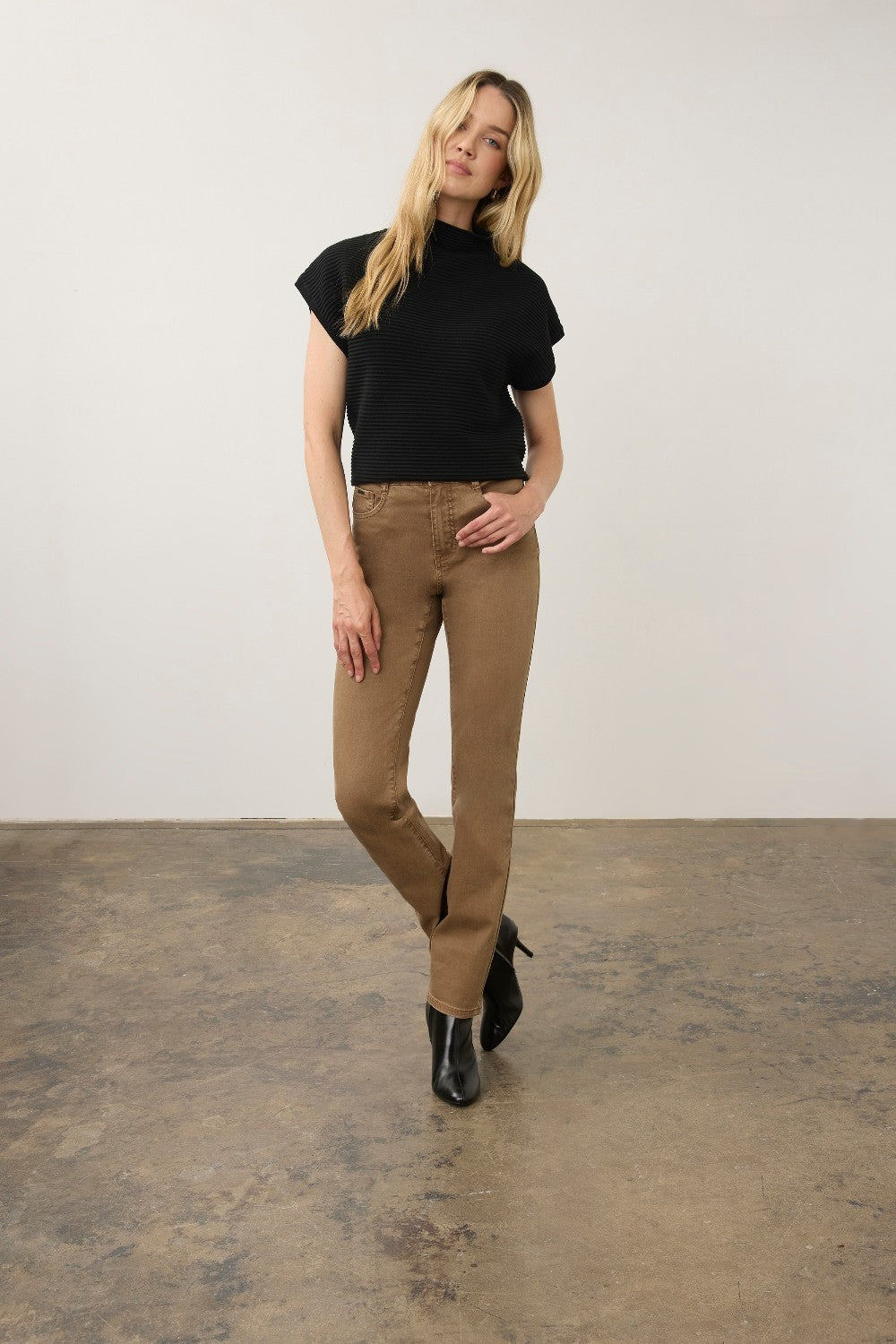 Model wearing Broderick's Clothing Co. FDJ Suzanne high-rise straight leg brown jeans with a black top and boots.