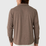 Back view of a man wearing a Broderick's Clothing Co. brown twill overshirt with long sleeves and buttoned cuffs.
