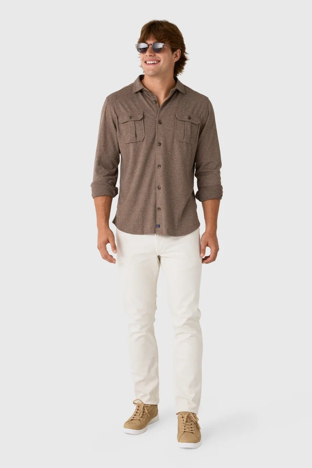 Broderick's Clothing Co. Johnnie-O brown twill overshirt with dual chest pockets worn by a smiling man in white jeans.
