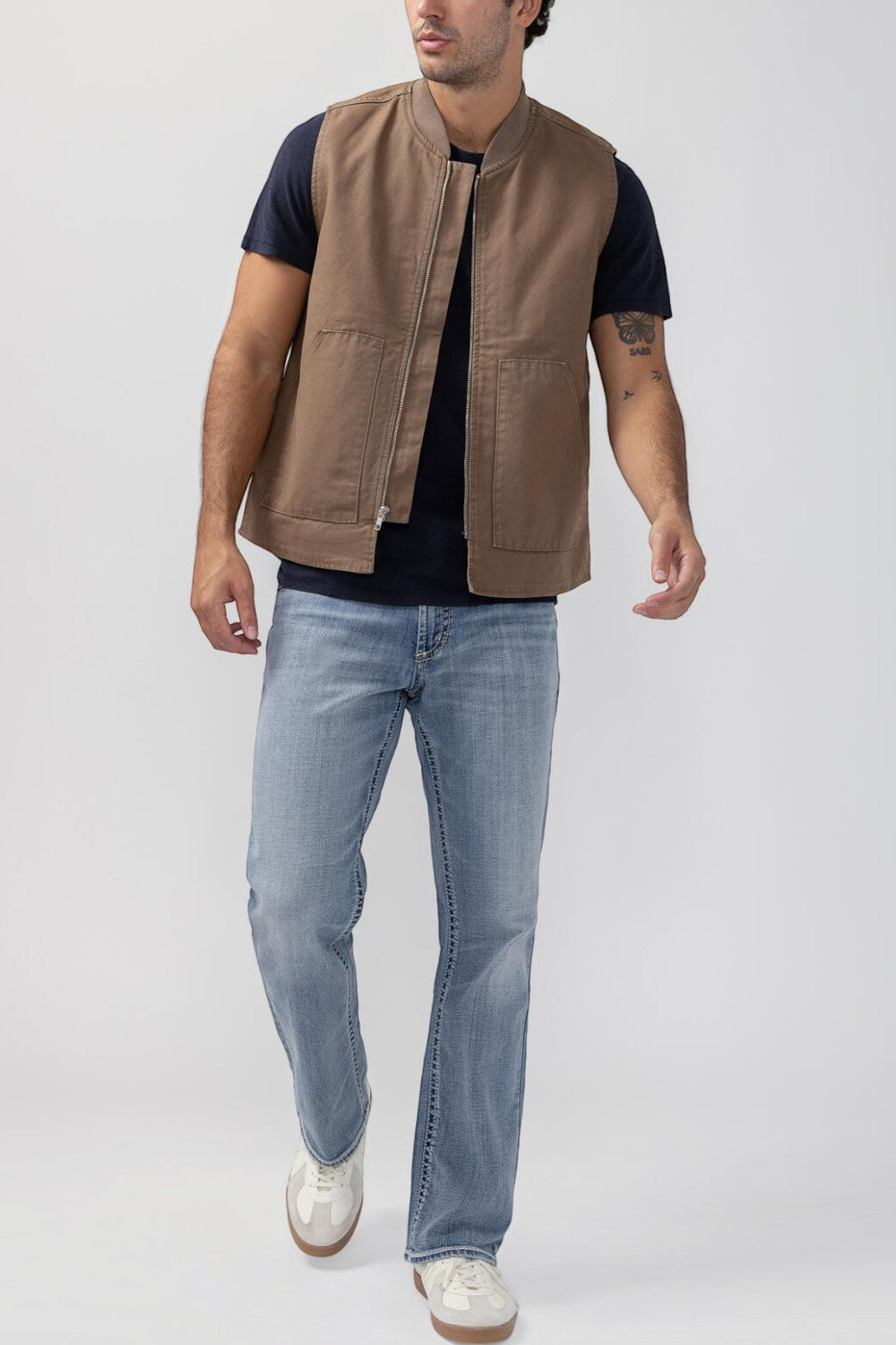 Broderick's Clothing Co. brown taupe workwear vest with zip front and patch pockets worn over a black t-shirt
