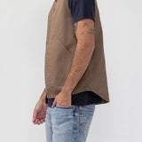Broderick's Clothing Co. brown taupe workwear vest with a zip front and patch pockets worn by a man in a t-shirt