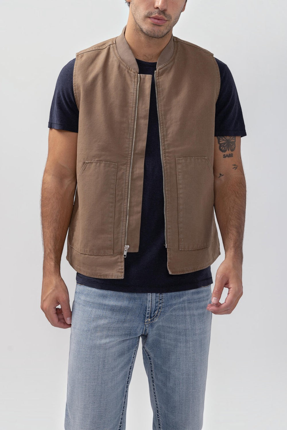 Broderick's Clothing Co. brown taupe rigid workwear vest with zip front and patch pockets worn by a man