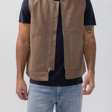 Broderick's Clothing Co. brown taupe rigid workwear vest with zip front and patch pockets worn by a man