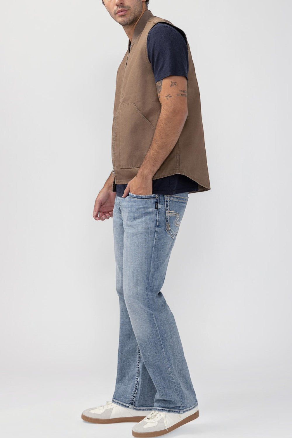 Broderick's Clothing Co. brown taupe workwear vest with zip front and patch pockets worn by a man in blue jeans