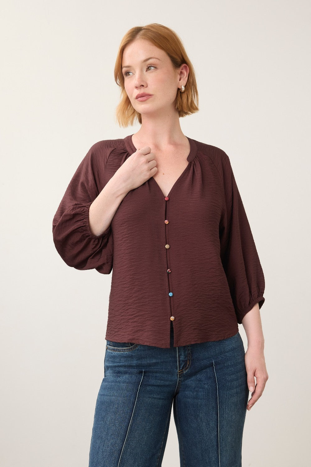 Broderick's Clothing Co. burgundy 3/4 sleeve blouse with colourful buttons worn by a woman with red hair.