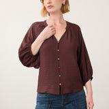Broderick's Clothing Co. burgundy 3/4 sleeve blouse with colourful buttons worn by a woman with red hair.