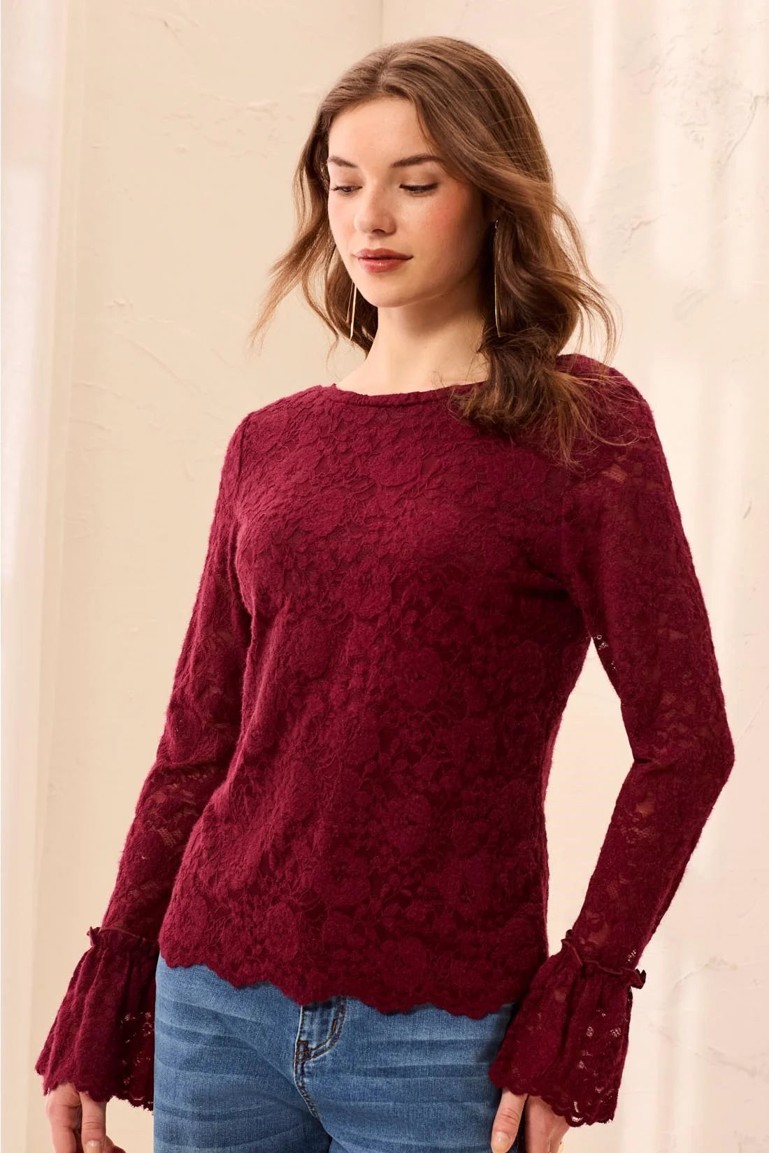 Broderick's Clothing Co. burgundy lace long-sleeve top with scalloped hem and flared cuffs worn with blue jeans