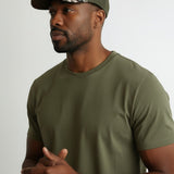 Broderick's Clothing Co. Goorin Bros. camouflage trucker hat with engraved bass patch worn by a man in an olive tee.