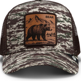 Broderick's Clothing Co. Goorin Bros. camo trucker hat featuring a brown leather patch with an engraved bear design.