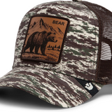 Broderick's Clothing Co. Goorin Bros. camo trucker hat featuring a brown leather bear patch and breathable mesh back.