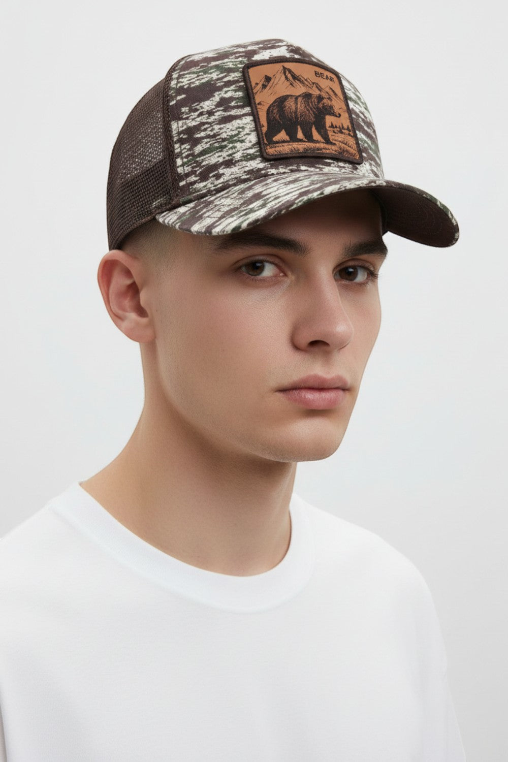 Broderick's Clothing Co. Goorin Bros. camo trucker hat with an engraved bear patch on a model against a white background