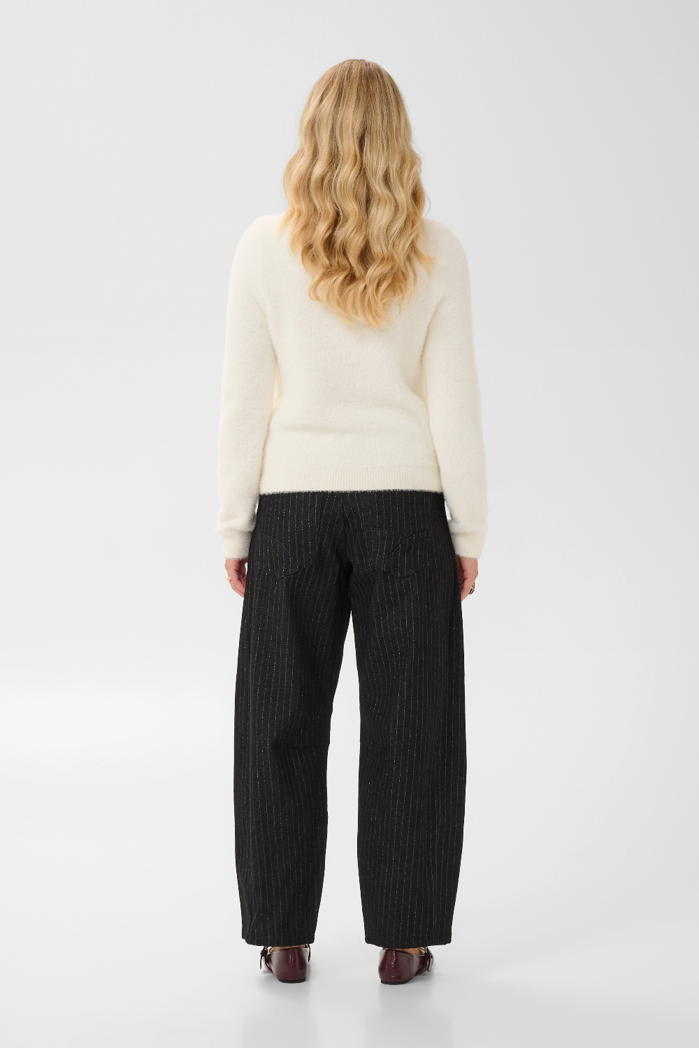 Broderick's Clothing Co. cream long-sleeve knit pullover with ribbed trim worn with black pinstripe trousers
