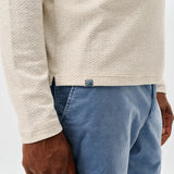 Broderick's Clothing Co. cream textured knit pullover with a hidden snap placket worn with blue shorts