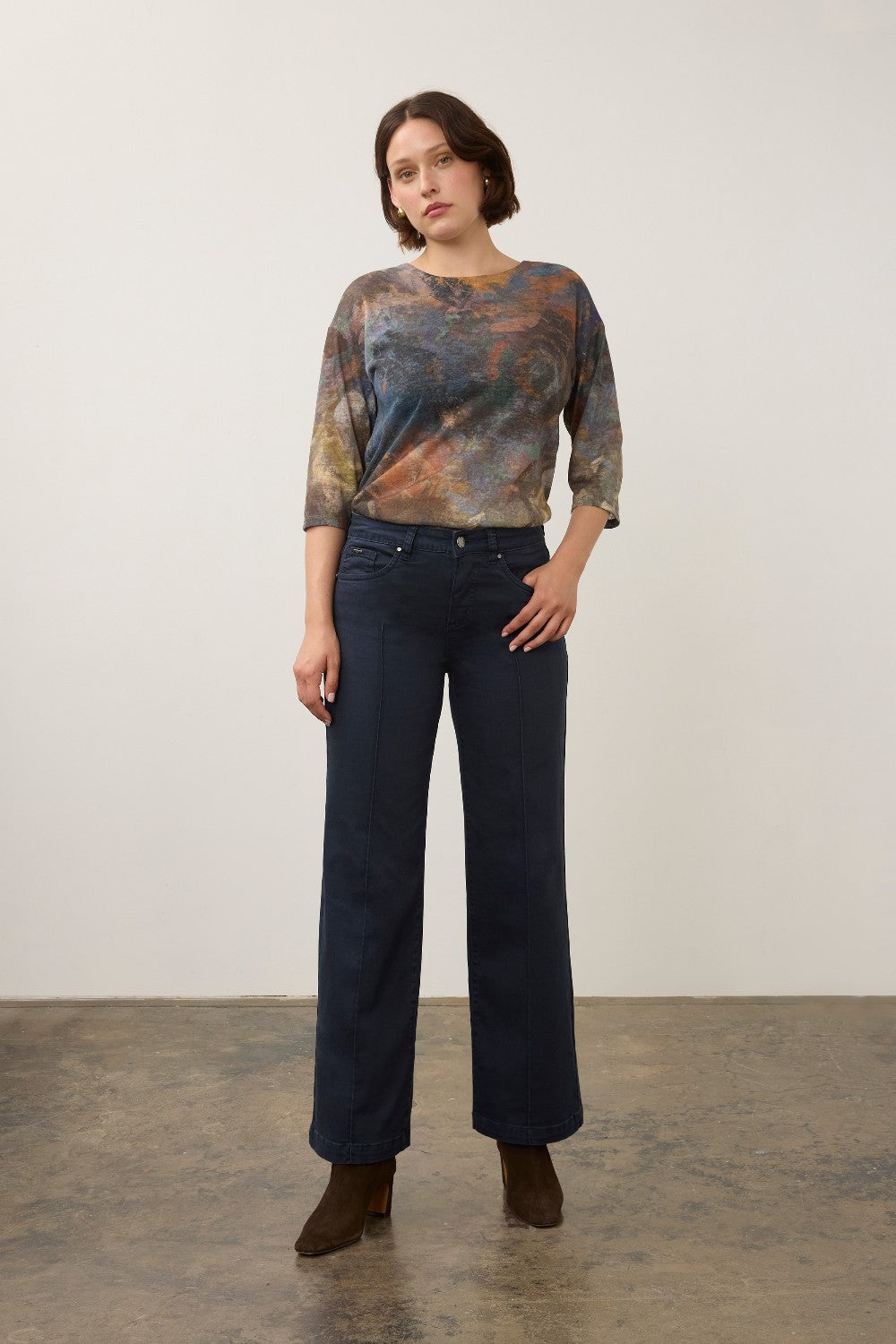 Model wearing Broderick's Clothing Co. FDJ Olivia wide leg navy pants with pintuck detail and a patterned top.