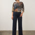 Model wearing Broderick's Clothing Co. FDJ Olivia wide leg navy pants with pintuck detail and a patterned top.