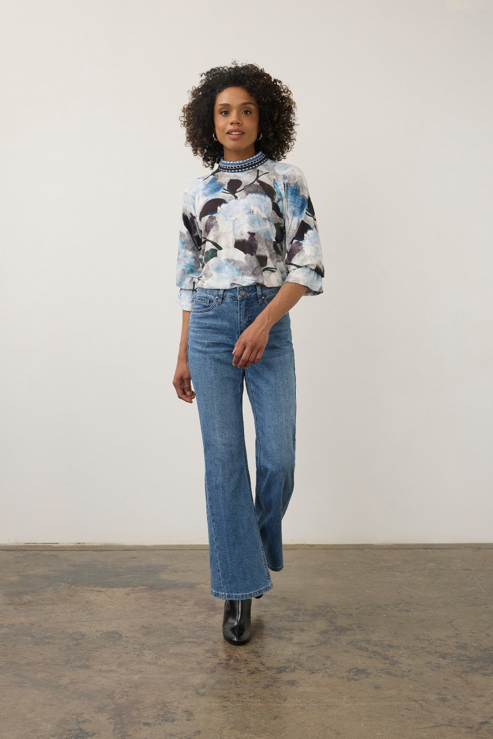 Model wearing Broderick's Clothing Co. FDJ floral print top with a high neck and blue denim flared jeans