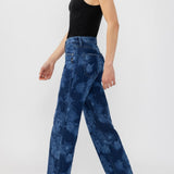 Broderick's Clothing Co. Avery high-rise straight leg jeans with a blue floral print on a model in a black tank top