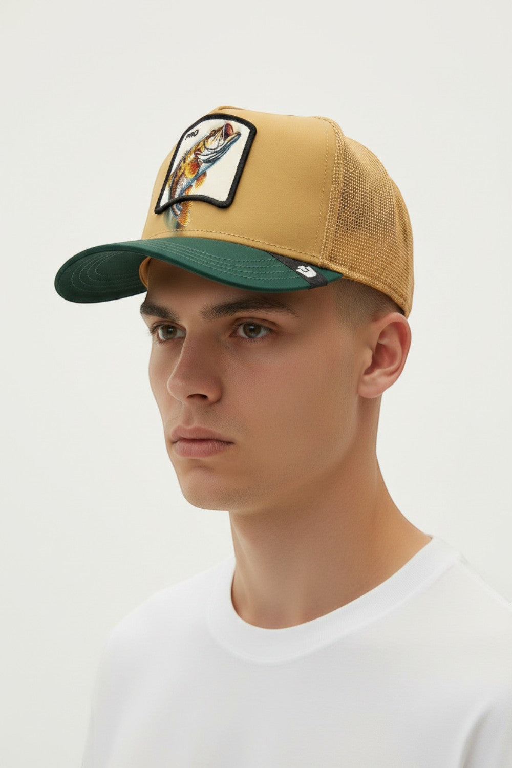 Broderick's Clothing Co. Goorin Bros. tan and green trucker hat with a fish patch worn by a man
