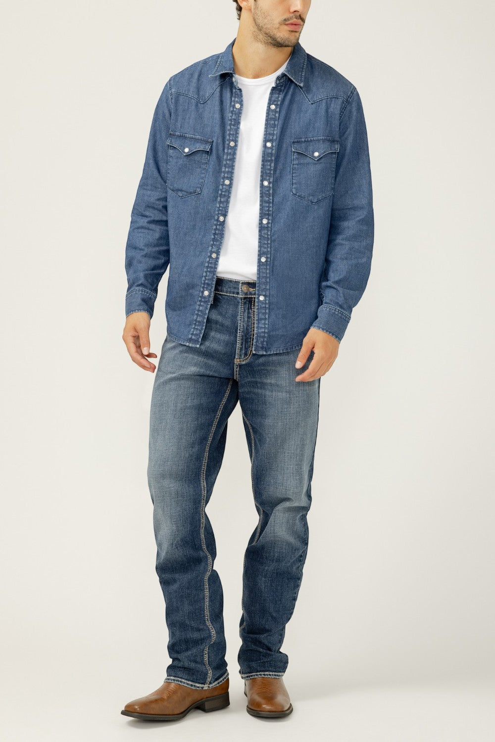 Broderick's Clothing Co. model wearing Silver Jeans Co. Grayson straight leg jeans with a denim shirt and boots