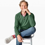 Broderick's Clothing Co. green reversible quarter-zip sweater worn by a smiling man with jeans and white sneakers.