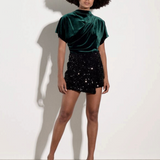 Broderick's Clothing Co. green velvet cowl neck top with batwing sleeves and ruched side detail on a model.