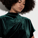 Broderick's Clothing Co. dark green velvet top with a high cowl neck, batwing sleeves, and elegant side ruching.