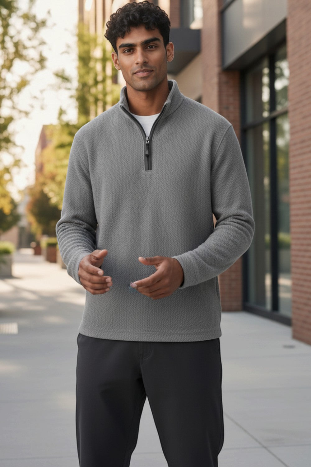 Man wearing a Broderick's Clothing Co. grey melange quarter-zip sweater with textured fabric in an outdoor setting.