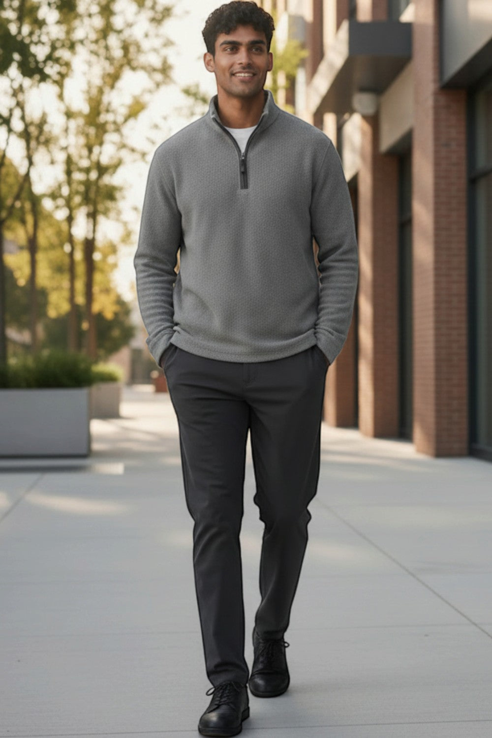 Broderick's Clothing Co. man wearing a grey melange quarter-zip sweater with dark trousers walking outdoors