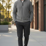 Broderick's Clothing Co. man wearing a grey melange quarter-zip sweater with dark trousers walking outdoors