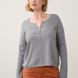 Broderick's Clothing Co. grey notch neck sweater with ribbed sleeves and colourful button detail on a female model
