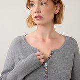 Broderick's Clothing Co. grey notch neck sweater with ribbed sleeves and colourful button detail on a woman