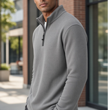 Man wearing a Broderick's Clothing Co. grey melange quarter-zip sweater with a textured knit finish outdoors.