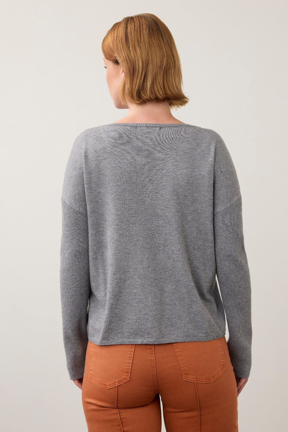 Back view of Broderick's Clothing Co. FDJ grey sweater with ribbed sleeves worn by a woman with short hair.