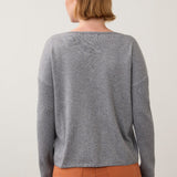 Back view of Broderick's Clothing Co. FDJ grey sweater with ribbed sleeves worn by a woman with short hair.