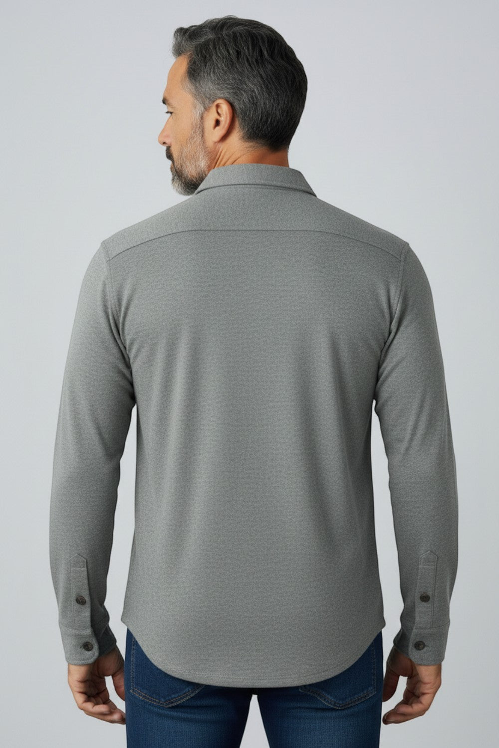 Back view of a man wearing a grey Johnnie-O Sequoia Twill Overshirt from Broderick's Clothing Co. over blue jeans.