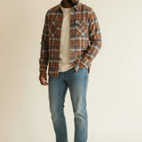 Broderick's Clothing Co. model wearing a Johnston & Murphy heathered plaid woven shirt with jeans and white sneakers.